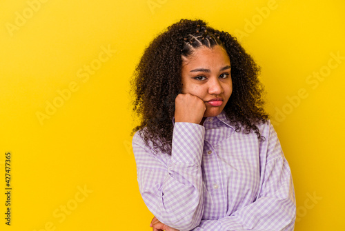 Young african american woman isolated on yellow background who feels sad and pensive, looking at copy space.