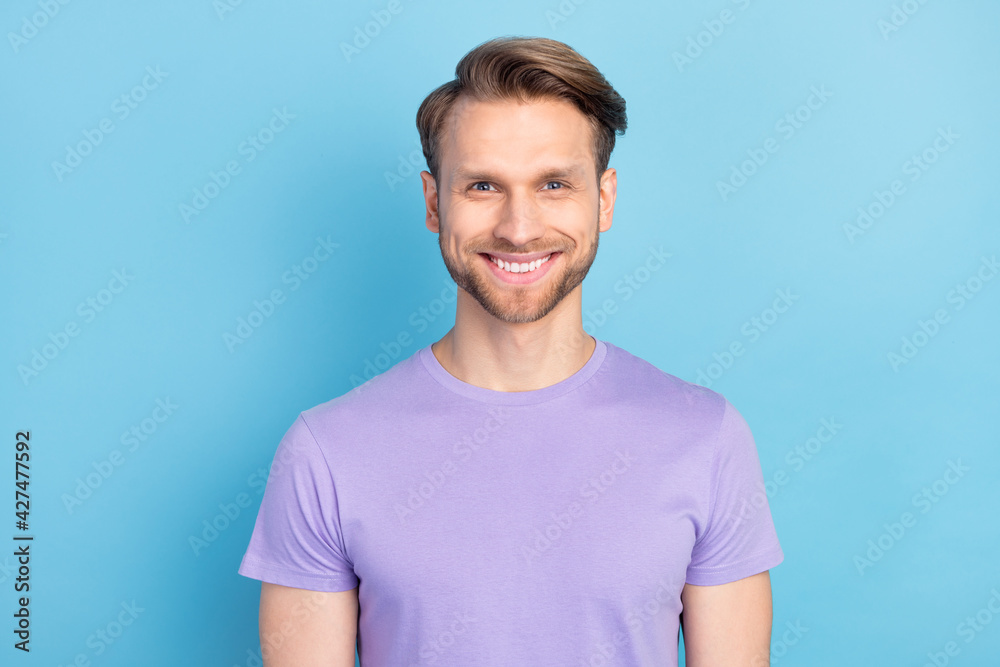 Photo portrait of smiling guy wearing purple t-shirt isolated on pastel blue color background