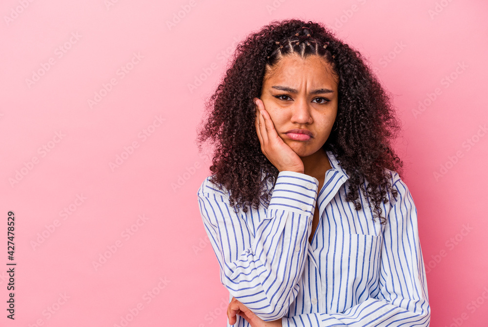 Young african american woman isolated on pink background who feels sad and pensive, looking at copy space. Young african american woman isolated on pink background who feels sad and pensive, looking at copy space.