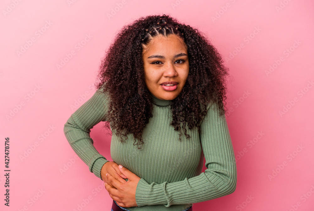 Young african american woman isolated on pink background having a liver pain, stomach ache. Young african american woman isolated on pink background having a liver pain, stomach ache.