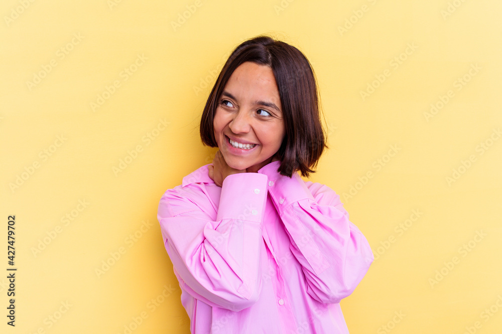Young mixed race woman isolated on yellow background stretching arms, relaxed position. Young mixed race woman isolated on yellow background stretching arms, relaxed position.