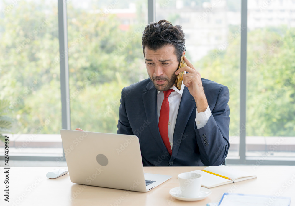 Stressed business man is on the call to discuss about business progress and project. He has serious face Stressed business man is on the call to discuss about business progress and project. He has serious face