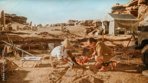 Archeological Digging Site: Two Great Archeologists Work on Excavation Site, Carefully Cleaning with Brushes and Tools Newly Discovered Ancient Civilization Cultural Artifacts, Fossil Remains