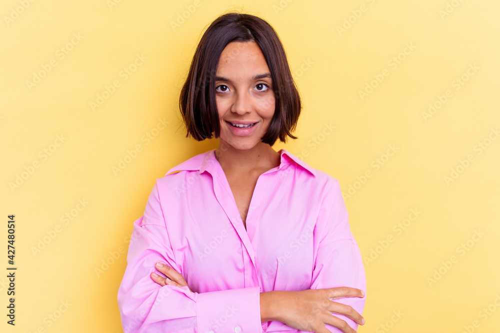 Young mixed race woman isolated on yellow background laughing and having fun. Young mixed race woman isolated on yellow background laughing and having fun.