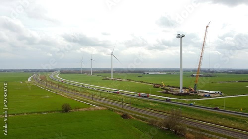 Construction of a new wind park with a row of large windturbines and a passing train near the Hattemerbroek junction next to the N50 highway in Gelderland, The Netherlands. photo