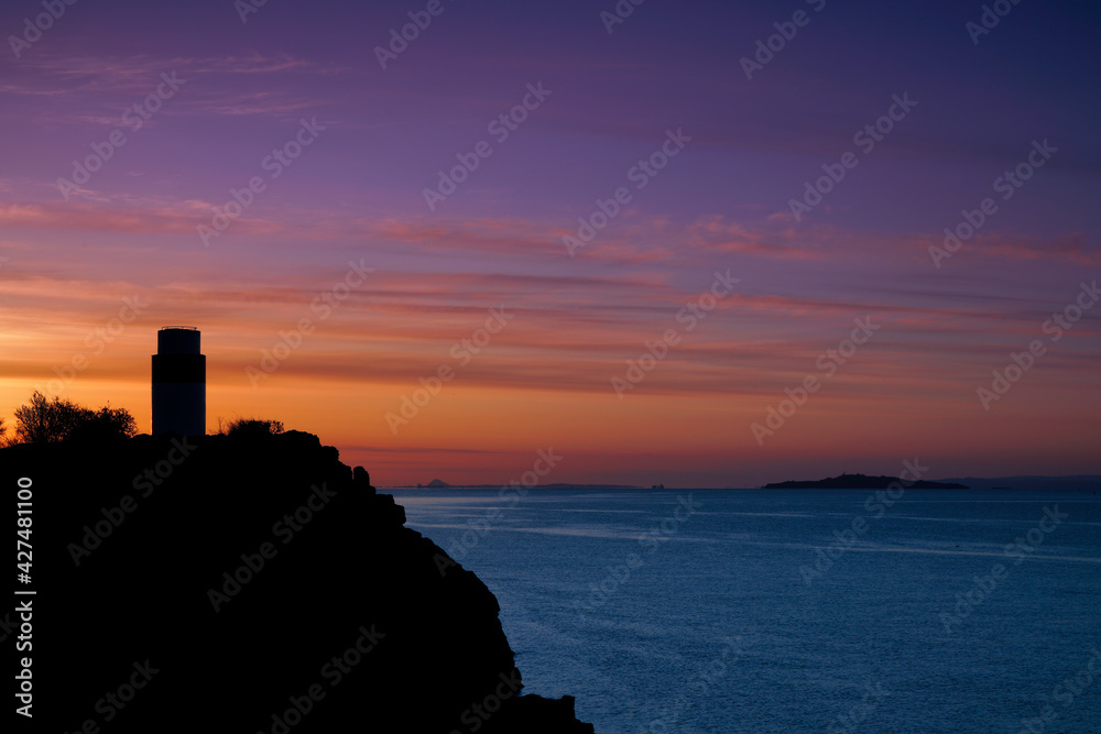 sunrise over a silhouette of Ha lighthouse in Aberdour, fife,  scotland.