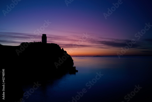 sunrise over a silhouette of Ha lighthouse in Aberdour, fife, scotland.
