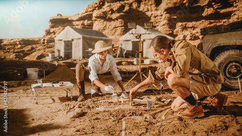 Archaeological Digging Site: Two Great Paleontologists Discovered Fossil Remains of Prehistoric Dinosaur, Clean it with Brushes. Archeologists Work on Excavation Site, Discover New Species Bones photo