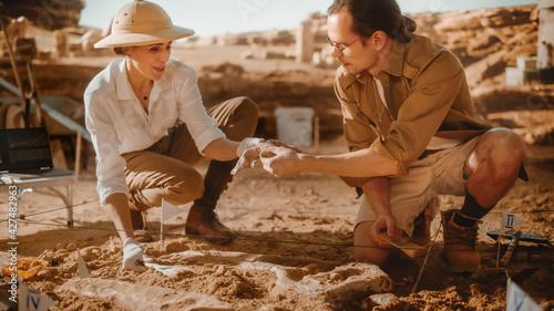Archaeological Digging Site: Two Great Paleontologists Pass Bone of a Newly Discovered of Dinosaur to Each Other. Archeologists on Excavation Site Discover Fossil Remains of Skeleton. Close-up Shot