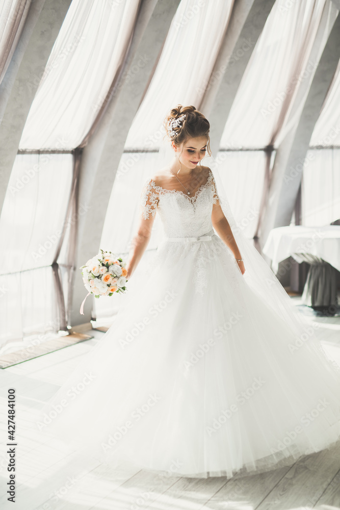 Portrait of stunning bride with long hair posing with great bouquet Portrait of stunning bride with long hair posing with great bouquet
