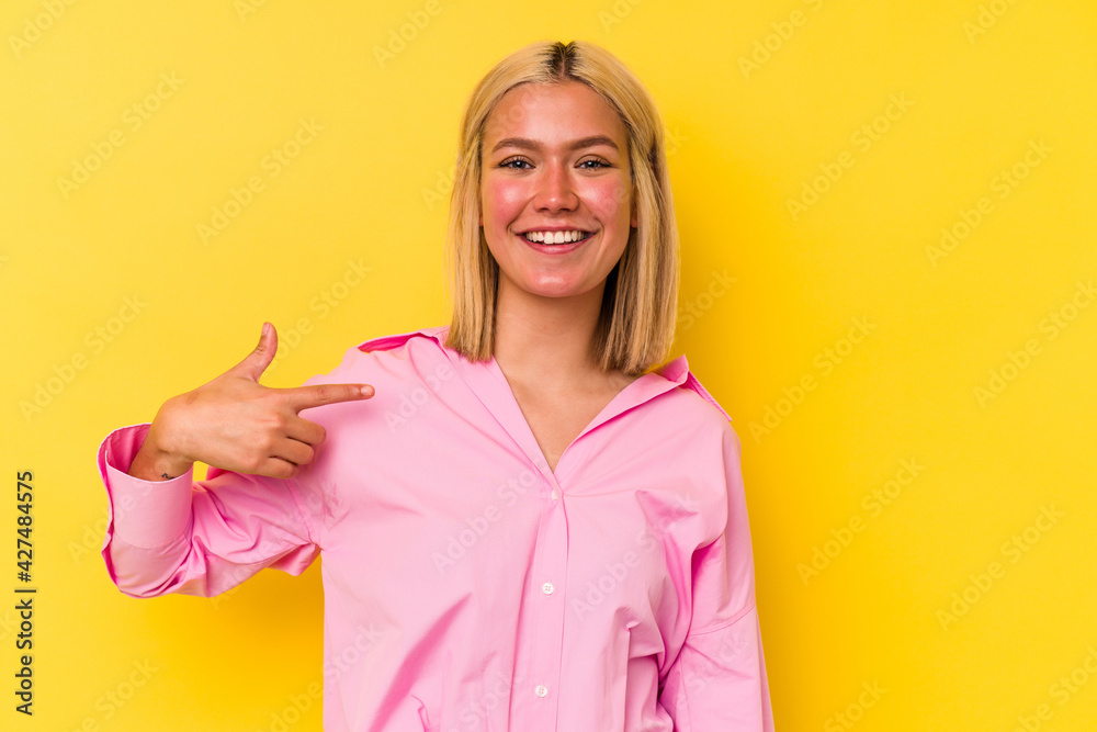 Young venezuelan woman isolated on yellow background person pointing by hand to a shirt copy space, proud and confident Young venezuelan woman isolated on yellow background person pointing by hand to a shirt copy space, proud and confident