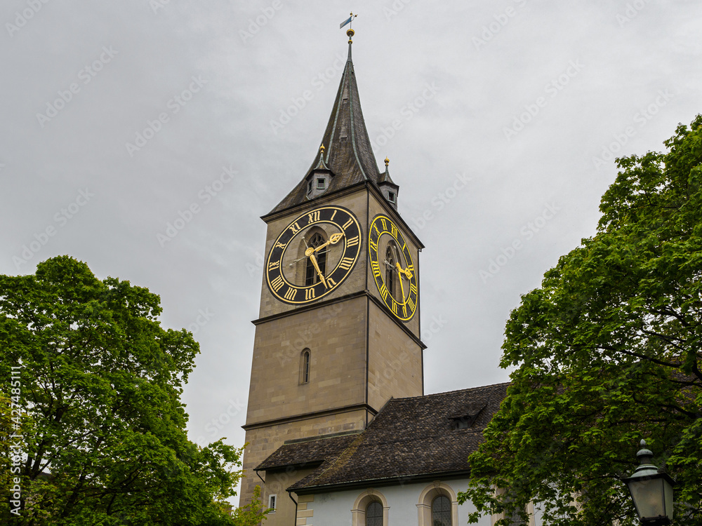 Clock tower of Saint Peter church under cloudy sky in Zurich, Switzerland