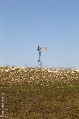 Lone water windmill on land in Flinthills of Kansas