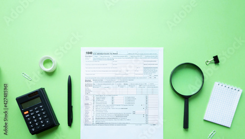1040 individual tax form. Pen, calculator, notepad and magnifier. Tax concept. With space for text