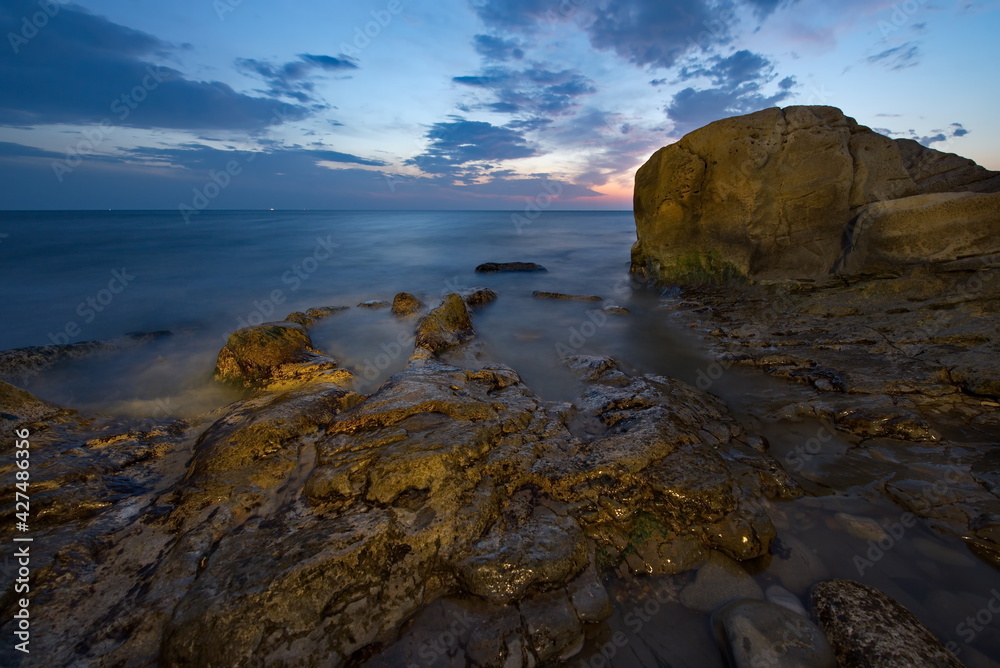 Russia. Dagestan. Dawn on the rocky shore of the Caspian Sea near the city embankment of Makhachkala.