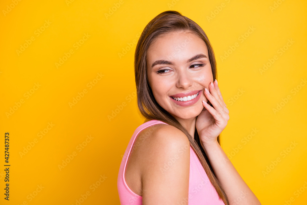 Profile side view portrait of attractive cheery brown-haired girl touching cheek enjoying copy space isolated over bright yellow color background Profile side view portrait of attractive cheery brown-haired girl touching cheek enjoying copy space isolated over bright yellow color background