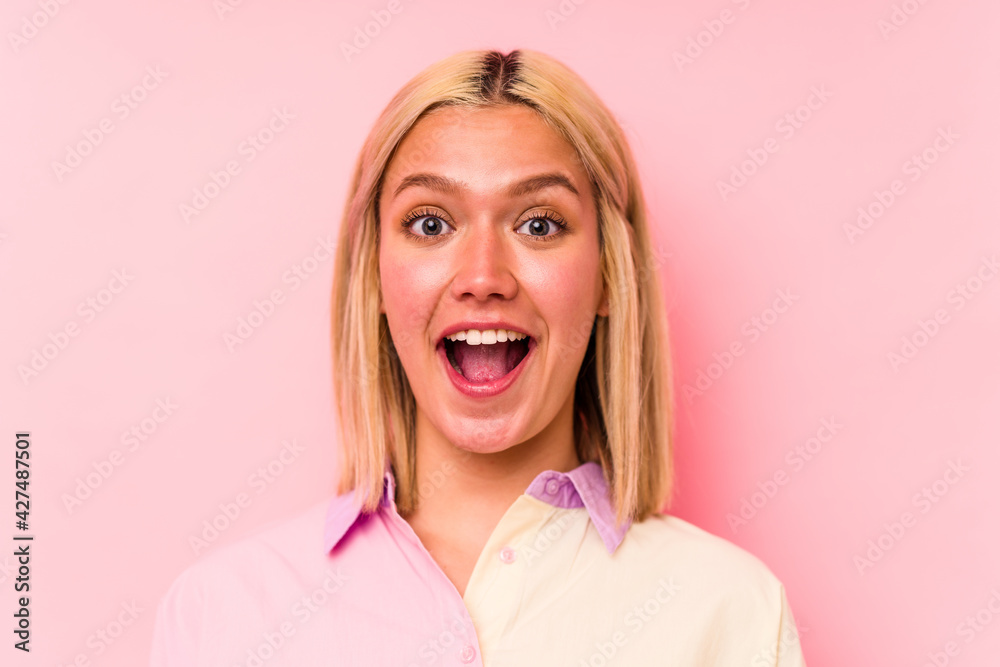 Young caucasian woman face closeup isolated on pink background