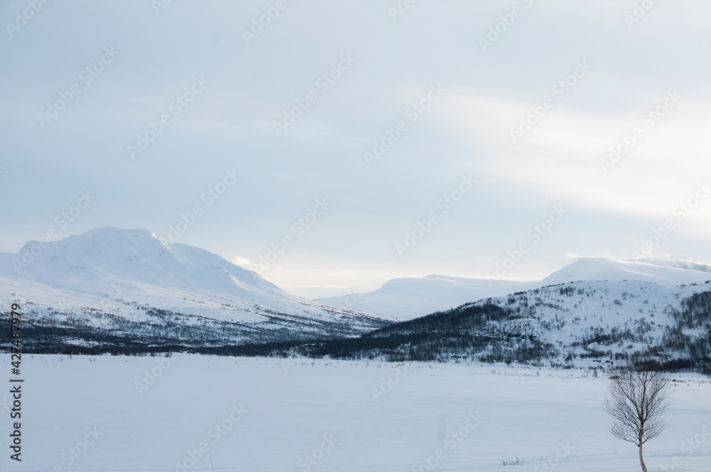 mountains in the winter, behind frozen lake