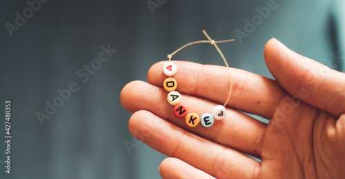 Thank you concept: Close up of bracelet with the german letters “Danke”