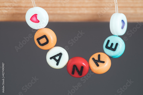 фотографія Thank you concept: Close up of bracelet with the german letters “Danke”