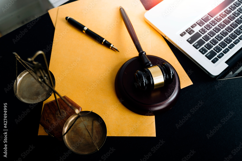 Business and lawyers discussing contract papers with brass scale on desk in office. Law, legal services, advice, justice and law concept picture with film grain effect Business and lawyers discussing contract papers with brass scale on desk in office. Law, legal services, advice, justice and law concept picture with film grain effect
