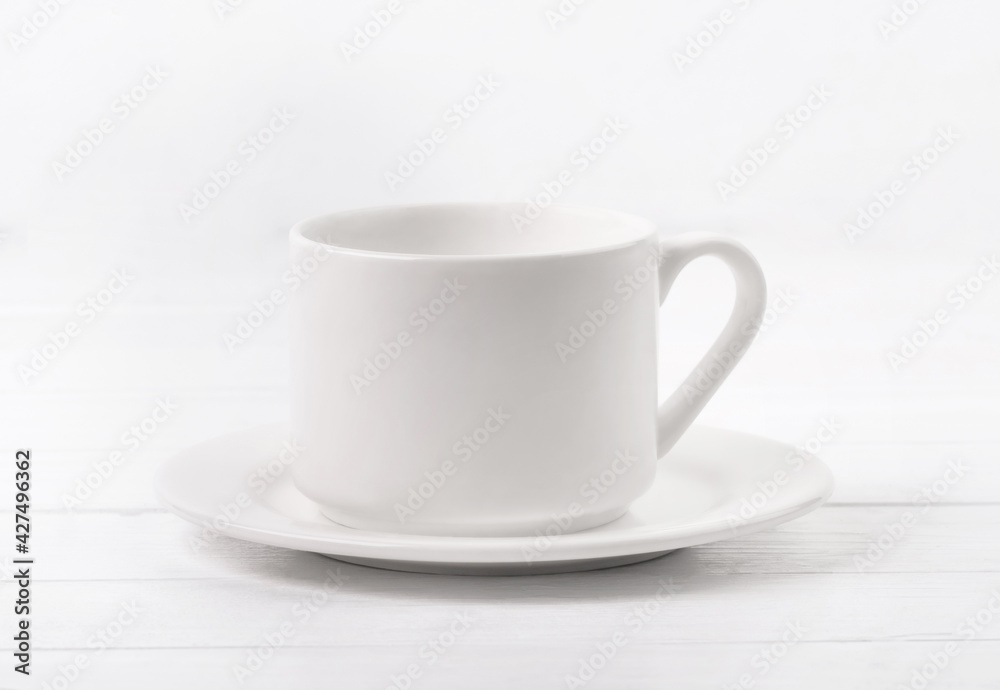 Blank white dish and cup on wooden table