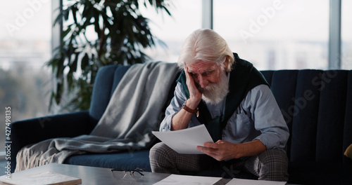 Fotografie Old unwell caucasian man crying over retirement letter frustrating when learning bad news