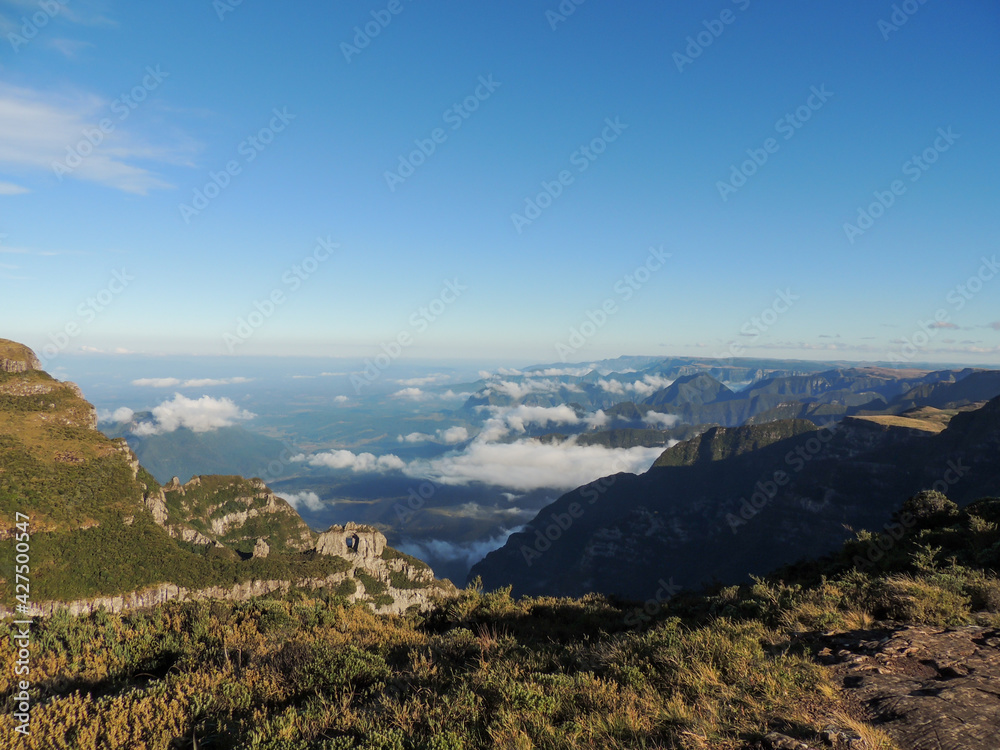 Landscape panorama with mountains and clouds flanking a valley. Highlighted the so-called pierced stone. View from the Church Hill, in Urubici, State of Santa Catarina, Brazil.