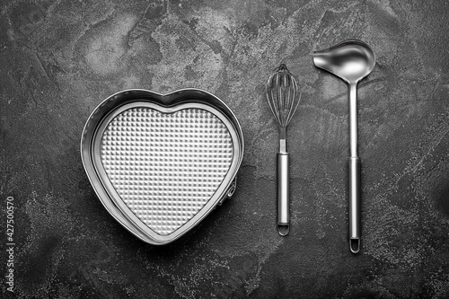 Different kitchen utensils on dark background
