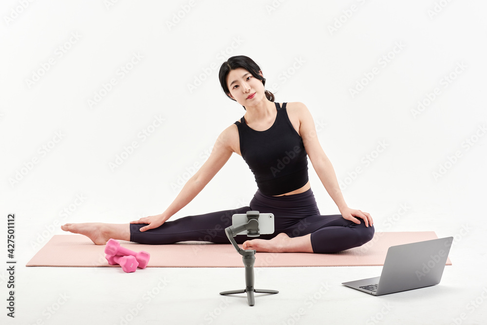 Asia Korean Girl training at white background , watching videos on laptop, and live streaming using gimbal in sns Asia Korean Girl training at white background , watching videos on laptop, and live streaming using gimbal in sns
