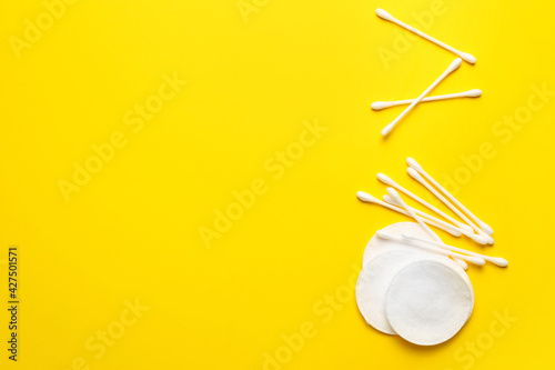 Cotton pads and swabs on color background