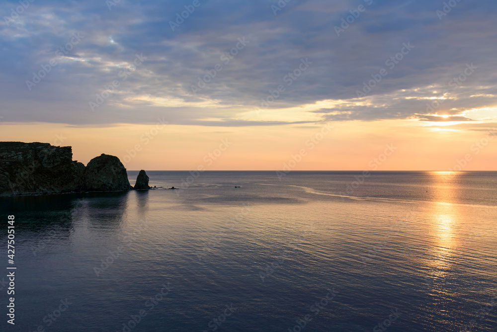 Fototapeta premium Sunset on the sea in front of a cape in the Aegean Sea on the island of Lemnos