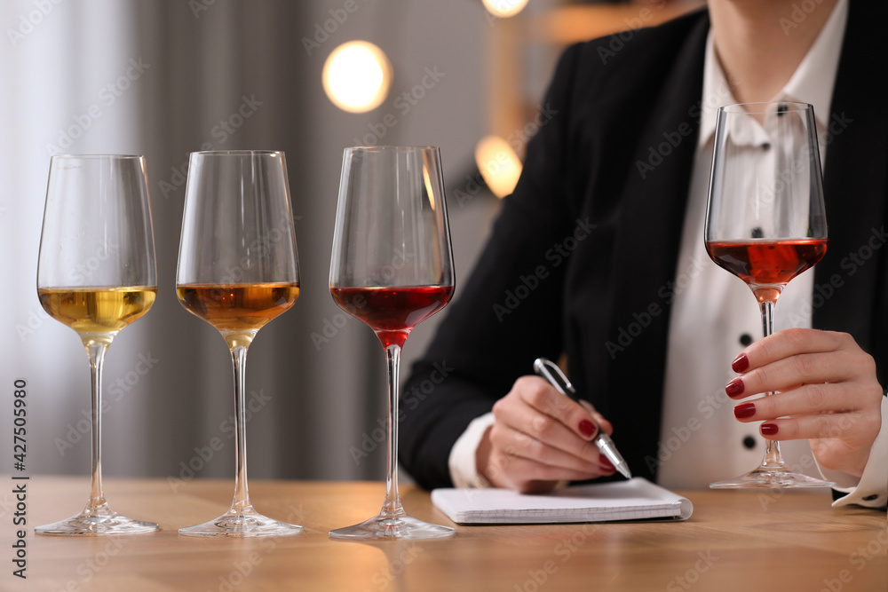 Sommelier tasting different sorts of wine at table indoors, closeup Sommelier tasting different sorts of wine at table indoors, closeup