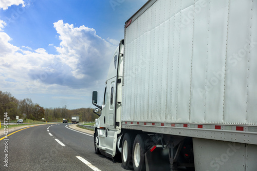 Truck on the highway, side view. cargo transportation concept. Cloudy blue sky