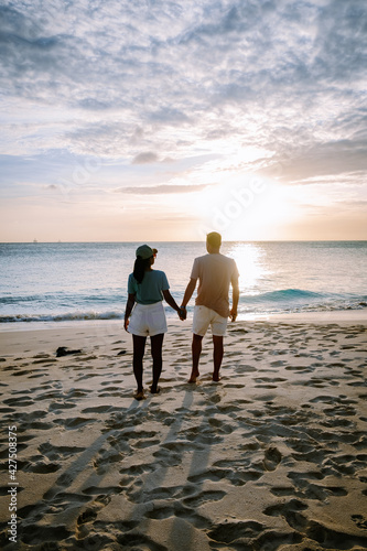 Sunset Aruba at Divi beach, colorful sunset at the beach in Aruba. couple men and woman mid-age Asian woman and European men on vacation Aruba photo