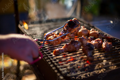 Billede på lærred Chef cooking jerk barbecue BBQ chicken on the grill hand turning food