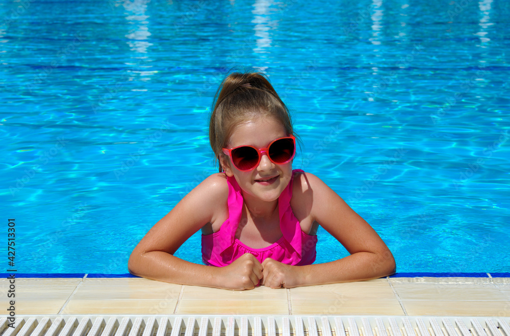 Little girl in sunglasses in pool