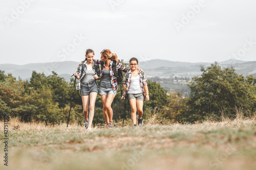 Mother hiking with her two daughter.They walking over the meadows and joying in nature. 