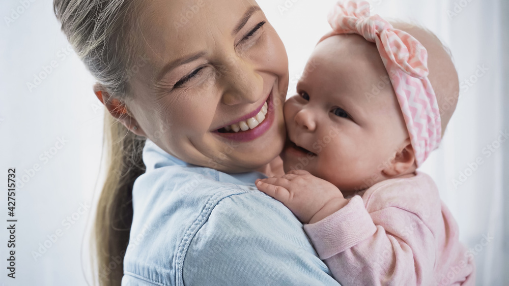 cheerful mother holding in arms happy baby daughter. cheerful mother holding in arms happy baby daughter.