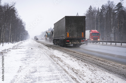 Trucks on the highway in dirty weather, Dangerous driving conditions in winter in cloudy weather.
