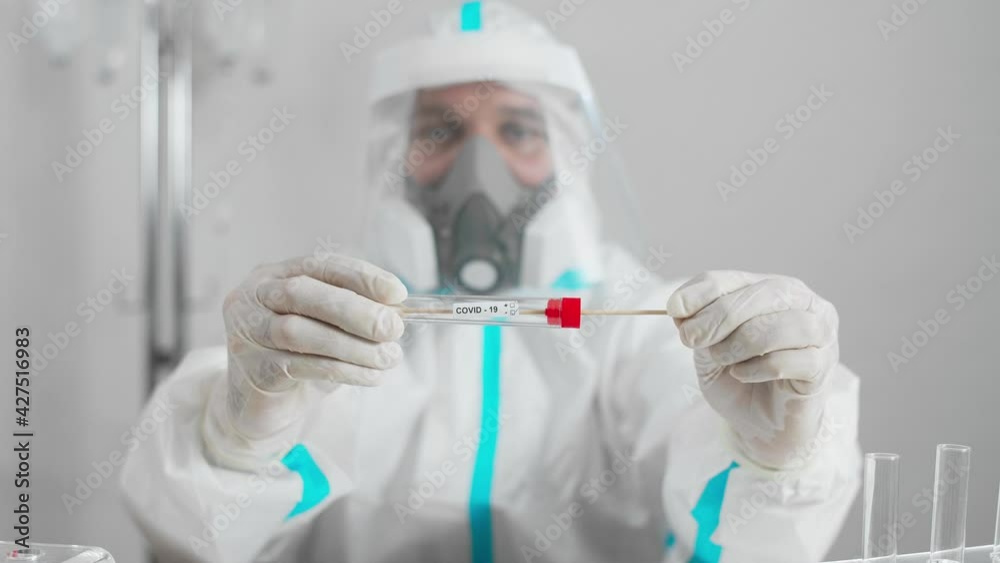 Medical worker in PPE showing negative COVID-19 test in hospital lab. Medical worker in PPE showing negative COVID-19 test in hospital lab.