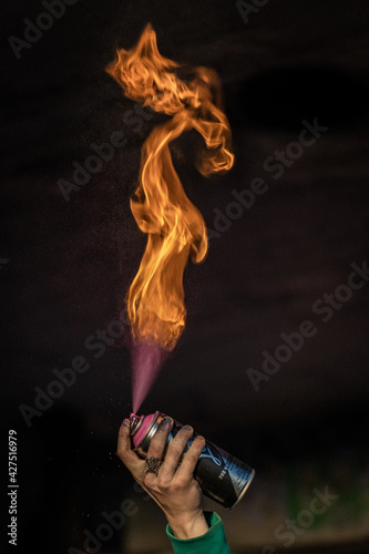 Vertical shot of an old lady's hand doing fire flame from a hand torch cylinder photo