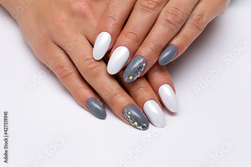 Gray  white manicure on long oval nails with glitters on nameless nails. Mirror white manicure. Rubbing on nails. Gel nail design.