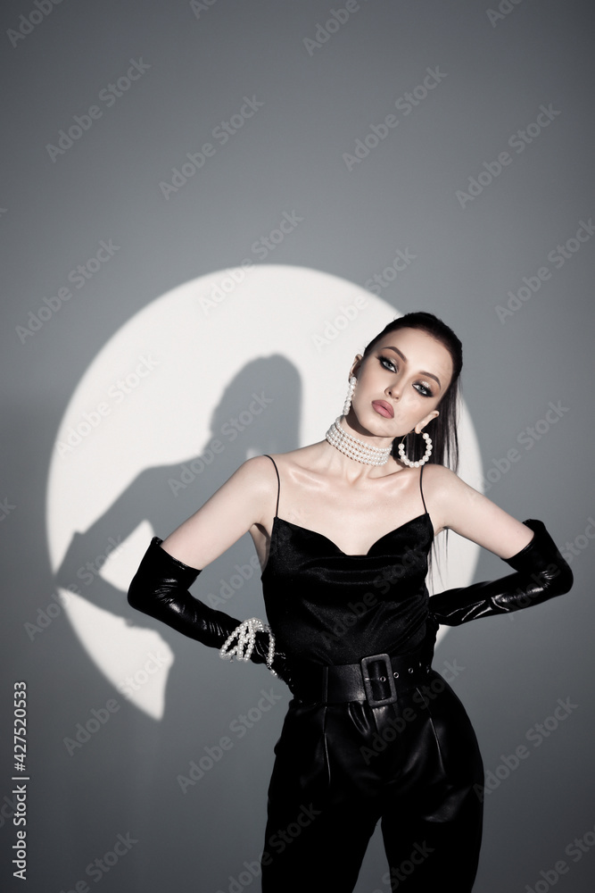 beautiful young girl model posing in studio, fashion photography. Studio light. The model is a slender young girl, European in black tight-fitting clothes beautiful young girl model posing in studio, fashion photography. Studio light. The model is a slender young girl, European in black tight-fitting clothes