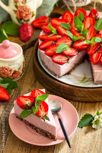 Summer diet dessert without baking Gluten-free, birthday menus. Strawberry cheesecake on a granola with fresh strawberries on a on rustic wooden table.