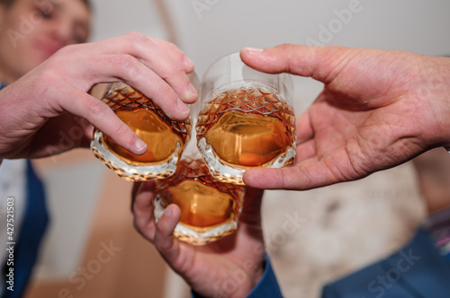 A glass of whiskey in the hands of a man