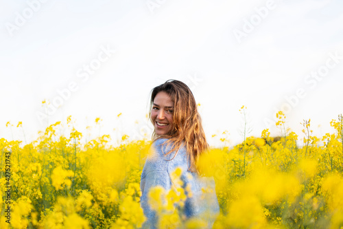 A happy girl in a meadow of yellow flowers © Laura
