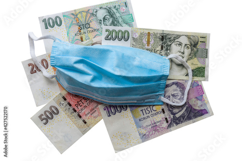 Various banknotes money on the table with protective medicine surgical mask over pandemic and epidemic influence on the economy and recession concept. Selective focus.
