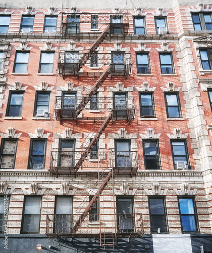 Old building with iron fire escape in New York City, USA.