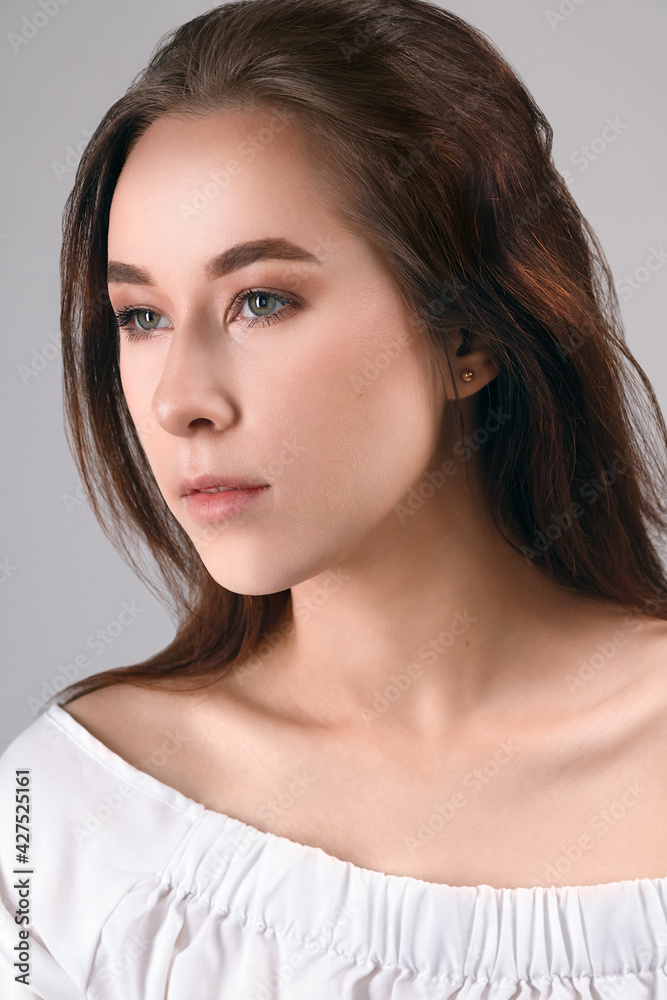 Natural beauty, portrait of a young woman. Stylish portrait of a young model in the studio on gray background. Beautiful natural makeup. Natural beauty, portrait of a young woman. Stylish portrait of a young model in the studio on gray background. Beautiful natural makeup.
